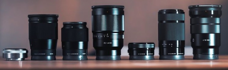 collection of different camera lenses, set out on a table
